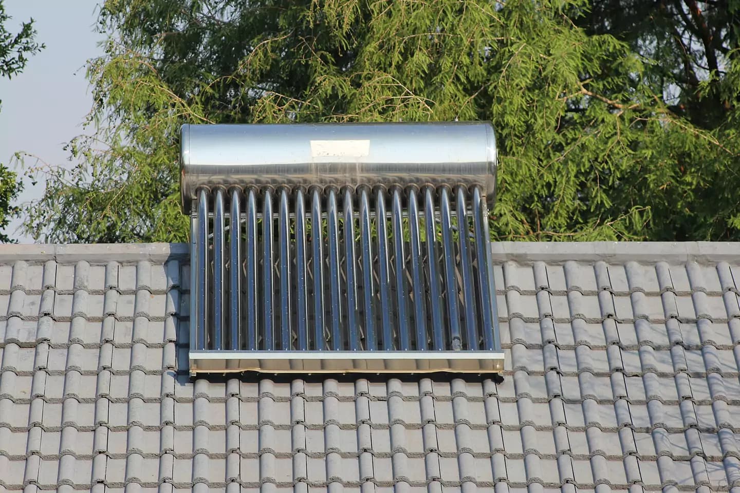 Solar water heater with evacuated tubes on a tiled roof