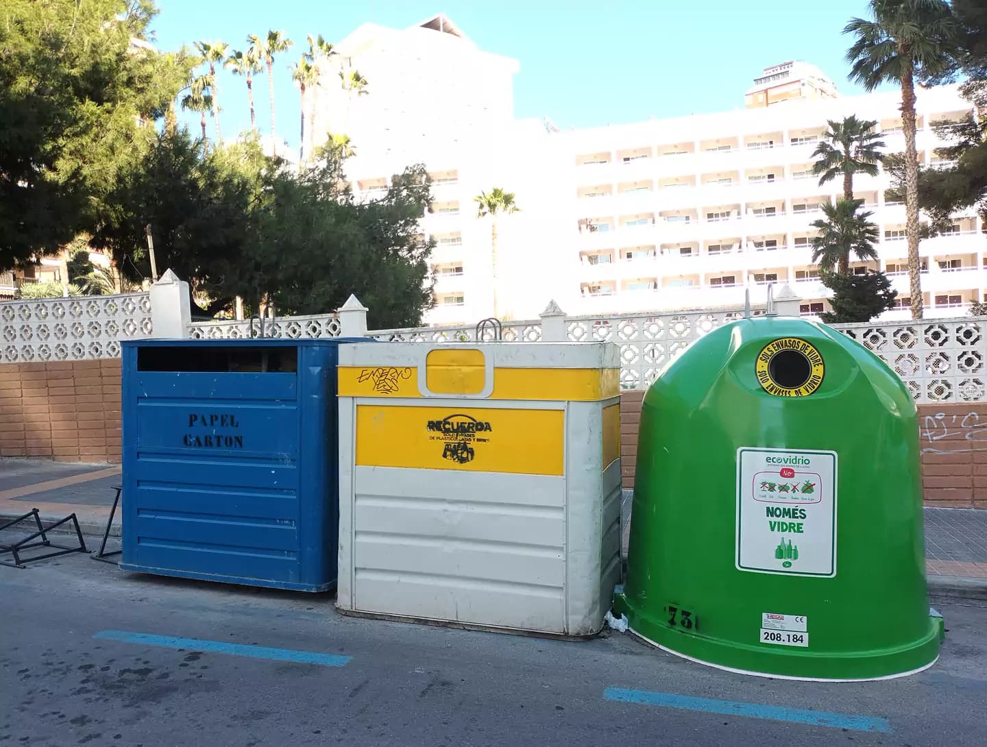 Blue, yellow and green recycling bins on a street